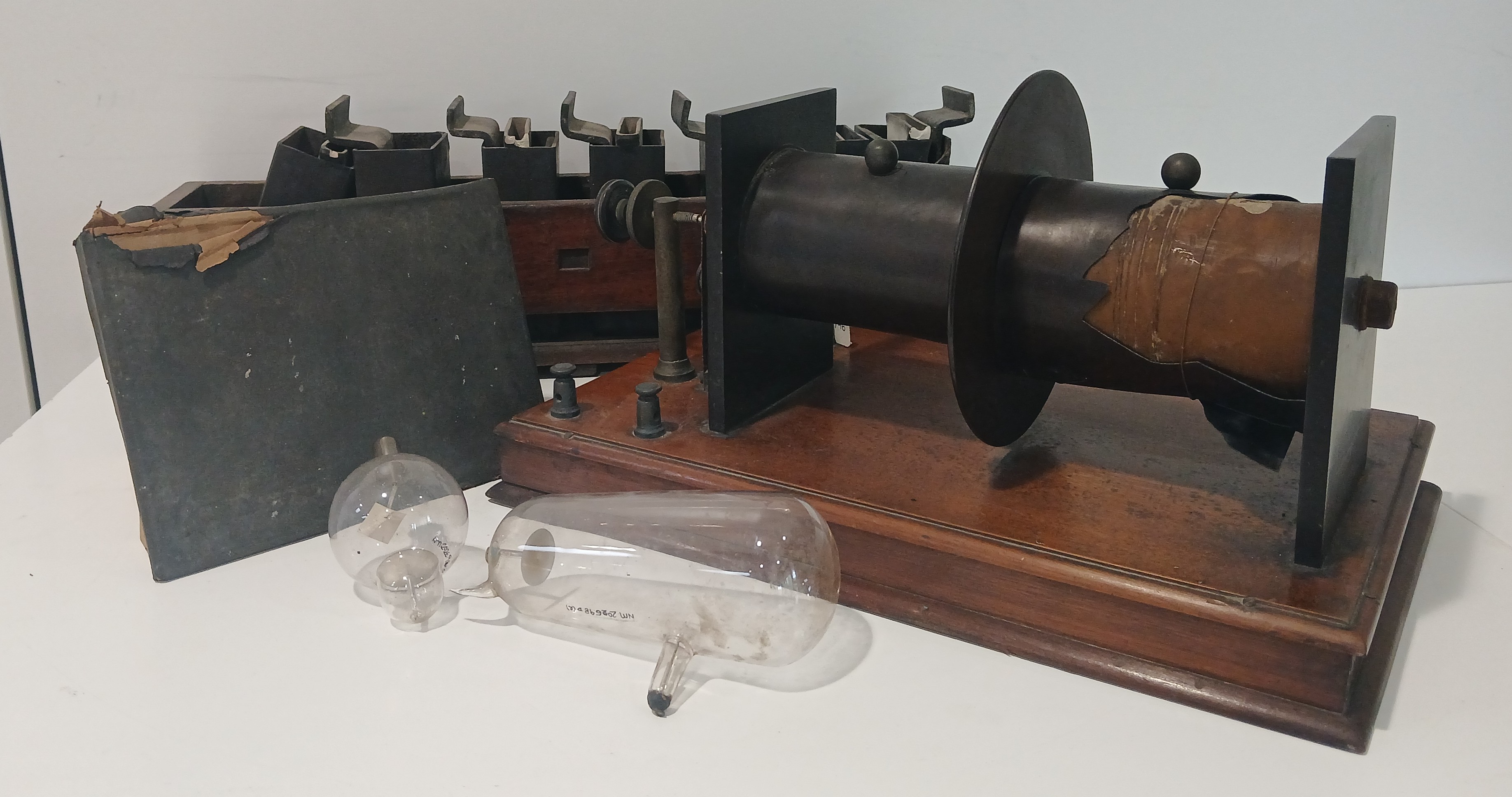 The X-Ray machine in the museums collection. Including 2 glass gloves, an induction coil on a wooden stand.