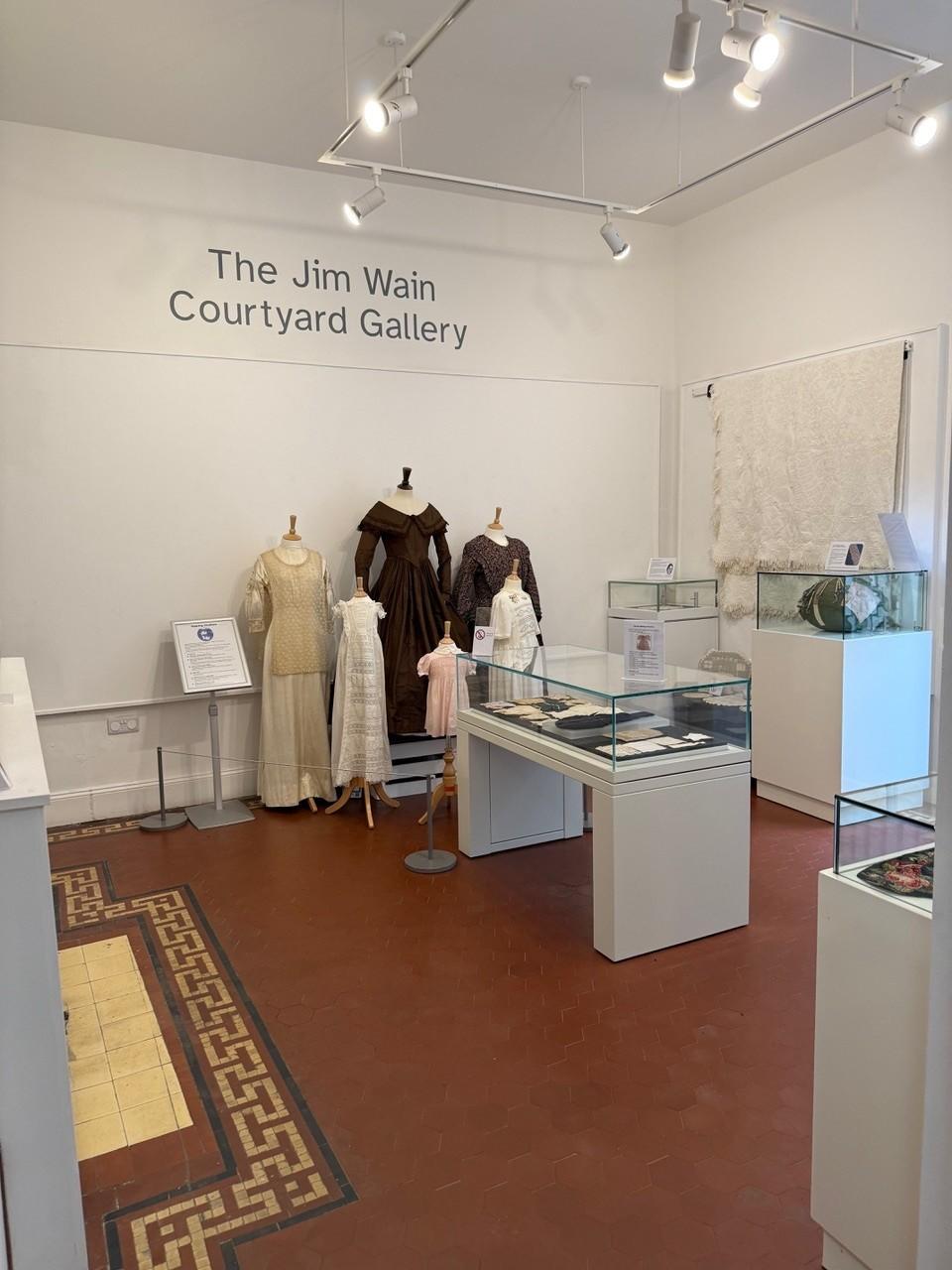 The image shows a display of handmade textiles items from the museum collection