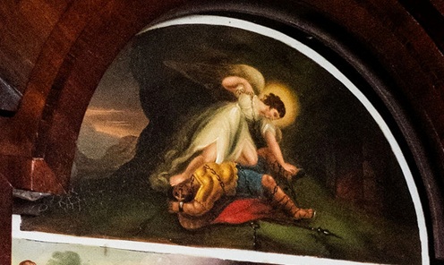 Painted clock arch with an angel holding changes above a prone figure