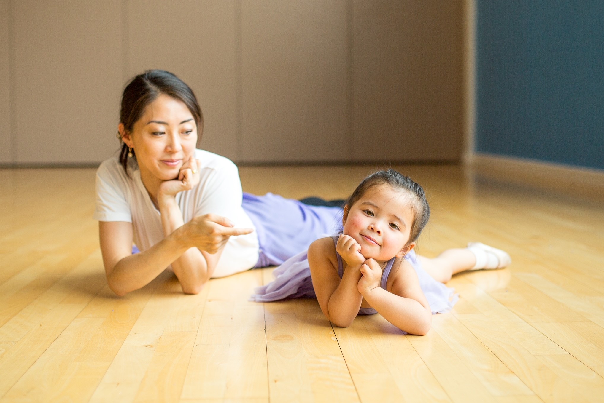 Kei and a young girl lying on the floor of dance studio