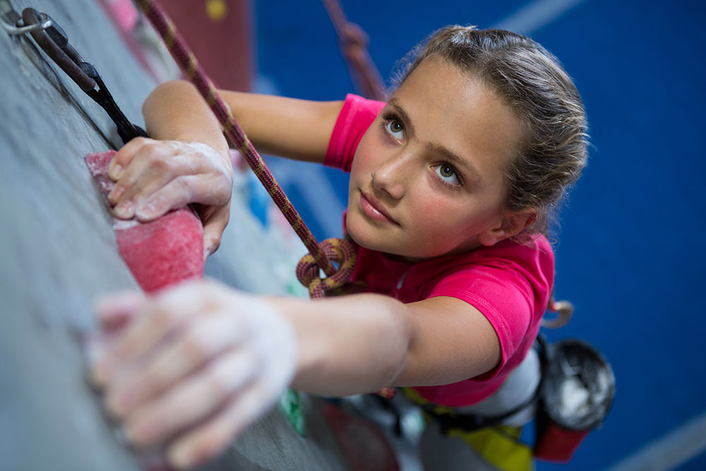 A girl climbing the climbing wall