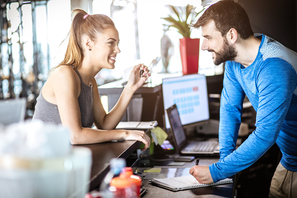 A woman talking to a man at reception