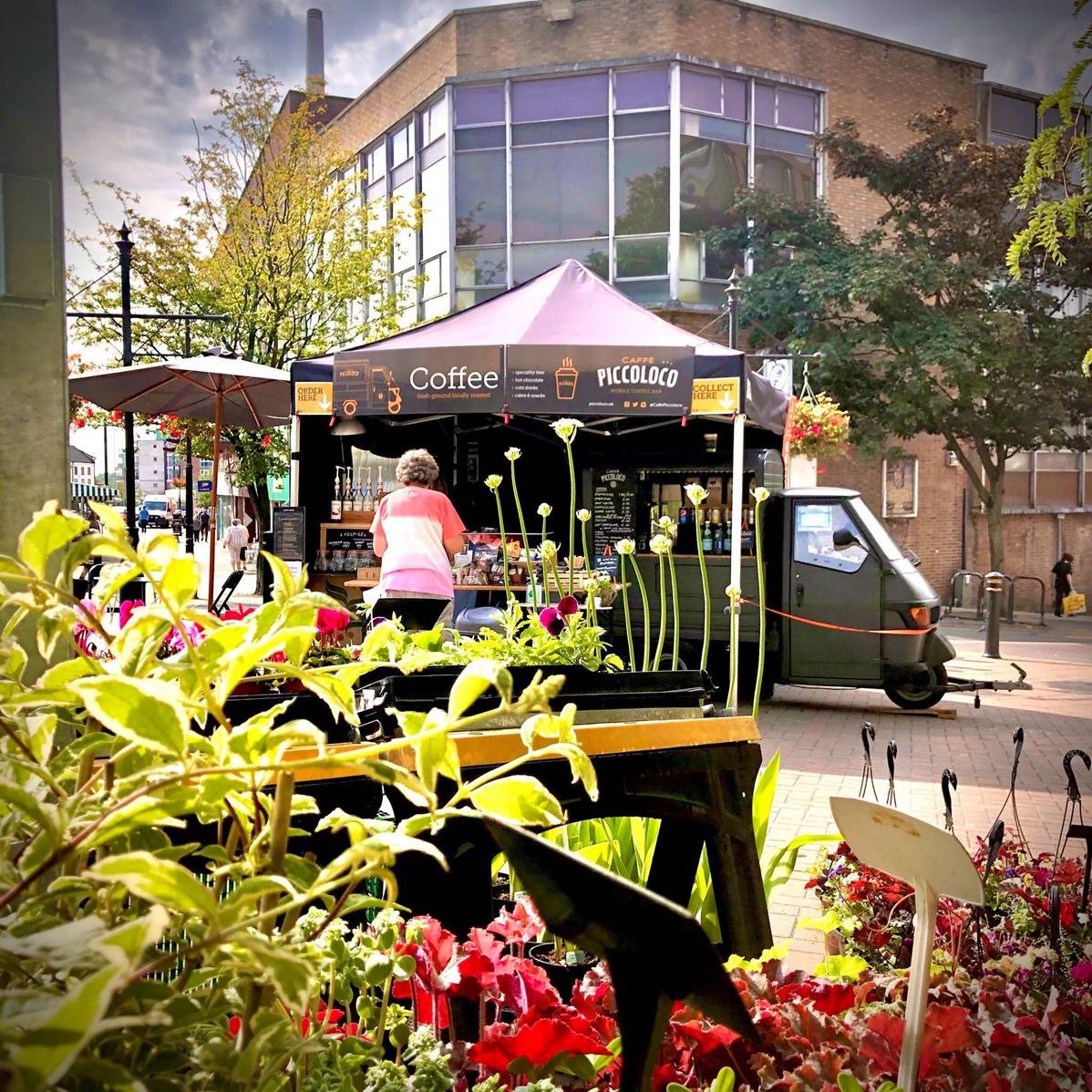 A photo of a coffee stall and colourful flowers.