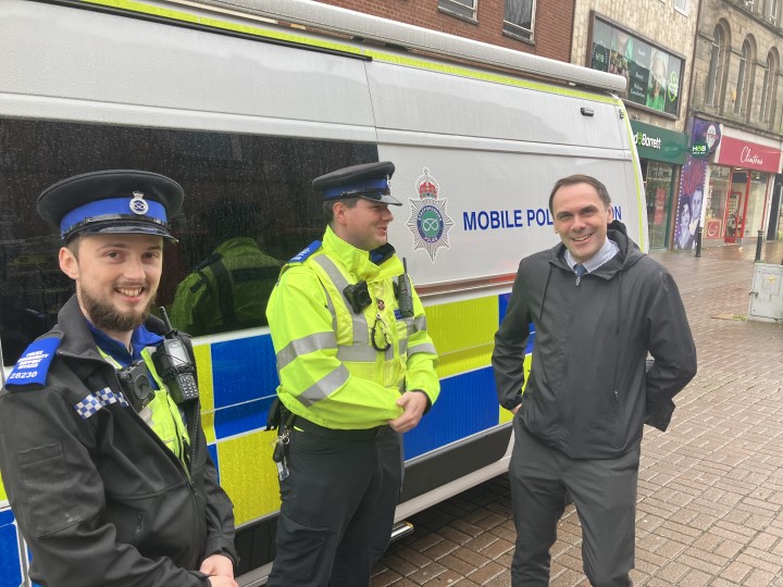 two police officers standing at side of police van with council leader Simon Tagg