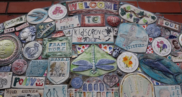 The image shows a collection of decorated tiles, made by school children, around the phrase 'Welcome to Kidsgrove'.