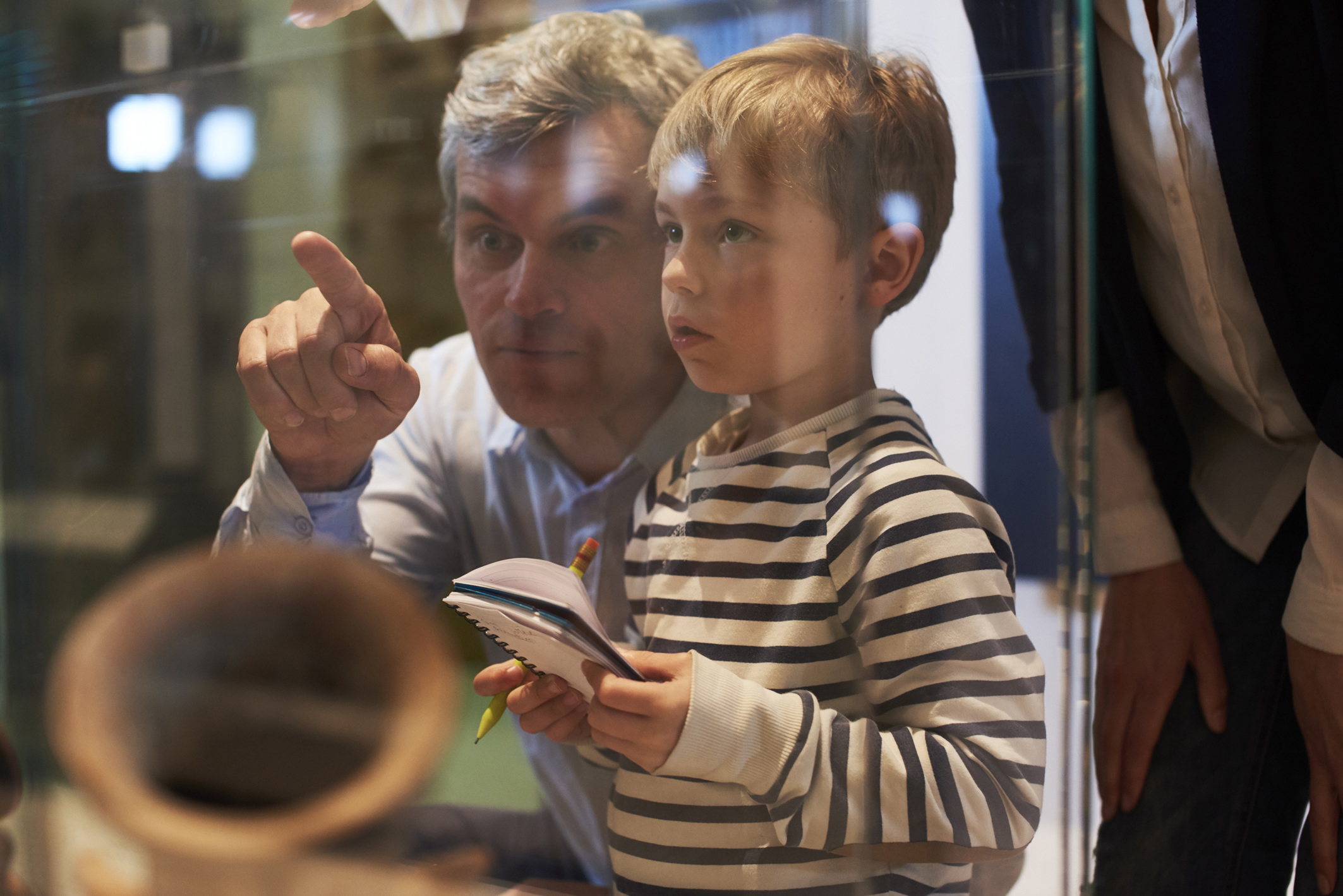 A man and young boy looking at an artifact