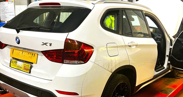 Image shows a car being inspected.