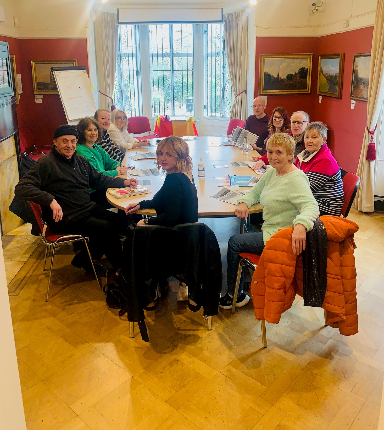 A smiling group of people sit in a meeting room