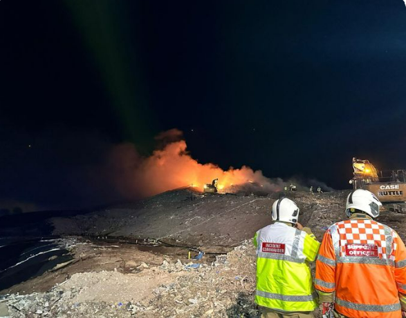 The image shows firefighters looking at the blaze at Walleys Quarry.