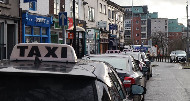 Image shows taxis waiting at a rank.